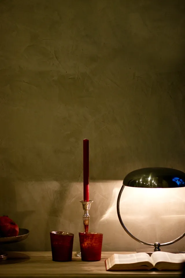 Foto mit einer Lampe, einem Kerzenständer und einem Buch als Beispiel von Objekten aus einer Haushaltsauflösung.